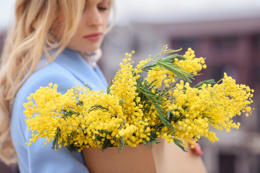 woman holding mimosa flower bouquet